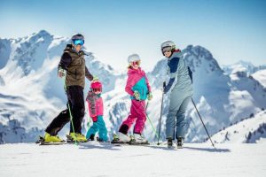 Famille au ski avec montagnes derrière