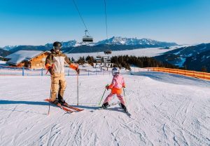 Parent avec son enfant qui apprend à faire du ski