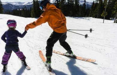 Une femme apprend à un enfant à skier