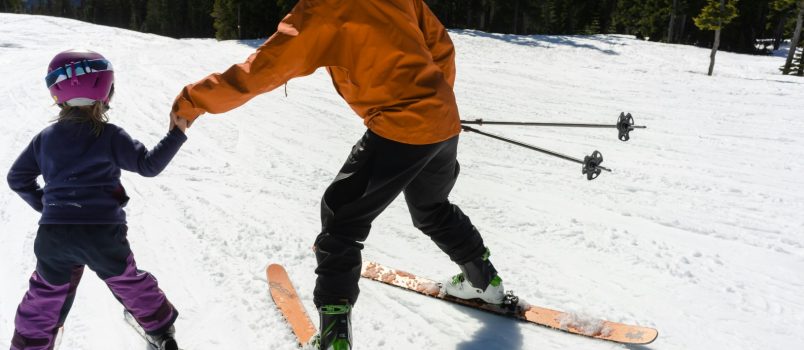 Une femme apprend à un enfant à skier